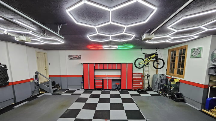 Complete Australian garage makeover featuring HexSpace hexagon LED lights overhead, black-and-white tile flooring, red tool storage and bike storage on the wall