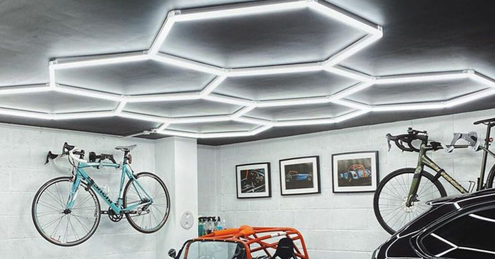 Hexagon lights above wall mounted bikes and a blue and orange race car
